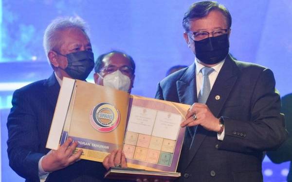 Ketua Menteri Sarawak Tan Sri Abang Johari Tun Openg (kanan) menunjukkan buku yang menceritakan sejarah penubuhan Suruhanjaya Perkhidmatah Awam Negeri Sarawak (SPANS) pada Majlis Pelancaran Sambutan Ulang Tahun ke 60 Penubuhan SPANS di banggunan Dewan Undangan Negeri Sarawak hari ini. - Foto Bernama