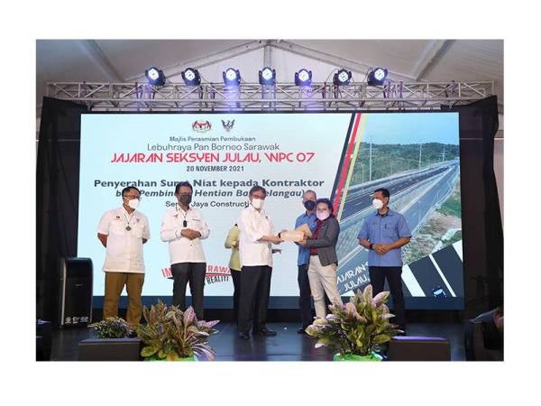 Ketua Menteri Sarawak, Tan Sri Abang Johari Tun Openg (tiga dari kiri ) menyerahkan surat kerja kepada seorang kontraktor sambil disaksikan Fadillah (tiga dari kanan) pada majlis pembukaan Seksyen Julau Lebuhraya Pan Borneo 20 November lalu.