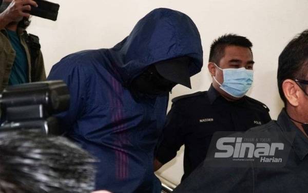 Mohd Fariq dibawa keluar dari Mahkamah Sesyen Ipoh selepas didakwa menerima suapan dalam kerja pengurusan jenazah.