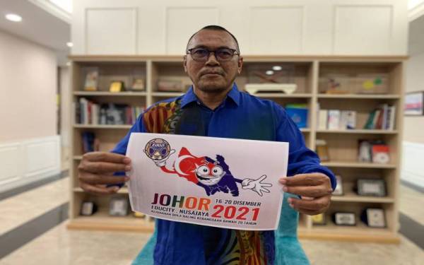 Pandak menunjukkan salah satu poster kejohanan bola baling tempatan yang akan diadakan pada 20 Disember depan.