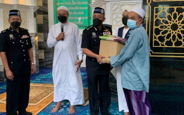 Shafien (dua dari kanan) menyampaikan sumbangan bakul makanan kepada masyarakat setempat di Masjid Ar Rahman Mukim Kubang Batang di sini.