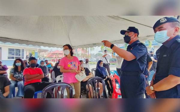 Shafien (dua dari kanan) bersama Abdul Rahim (kanan) turun padang melihat pembayaran saman sempena Program 100 Hari Aspirasi Keluarga Malaysia (AKM) di Ibu Pejabat Polis Daerah (IPD) Kota Bharu pada Sabtu.