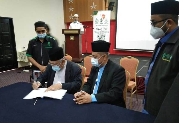 Mohd Azmi (kiri) dan Dr Muhammad Nasri menandatangani perjanjian persefahaman gerakan dakwah Kedah sempena Bengkel Gerakan Dakwah Negeri Kedah di Alor Setar.