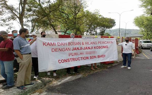 Azhari (kanan) bersama penduduk di Taman Melawati berkumpul bagi membuat bantahan terhadap projek pembetungan yang terbengkalai di sini pada Ahad.