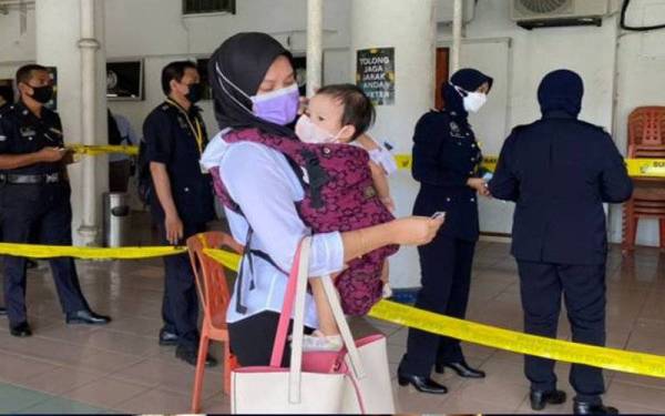 Lynne terpaksa membawa anaknya membuang undi disebabkan pengasuhnya masih bercuti. - Foto Astro Awani
