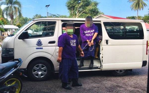 Suspek (kiri) ketika dibawa ke mahkamah di Kemaman pada Selasa bagi proses tahanan reman.