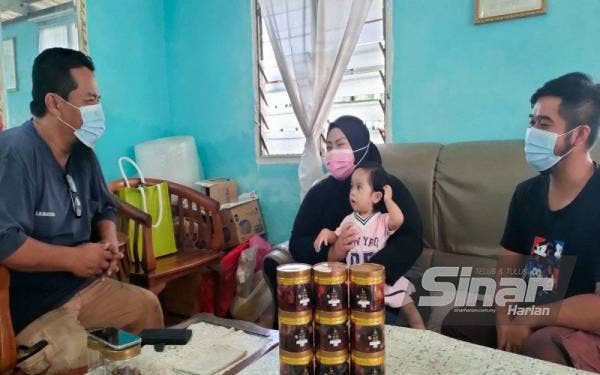 Shikh Muhammad (kiri) ketika menyantuni keluarga Nuridayu di Kampung Gangsa, Durian Tunggal, di sini, pada Selasa.