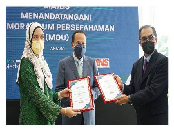 Salina (kiri) bertukar-tukar dokumen MoU dengan Pengarah Urusan Kumpulan USAINS Tech Services Sdn. Bhd, Farid Wajidi Mat Yusoff (kanan), disaksikan oleh Dr Ahmad Samsuri.