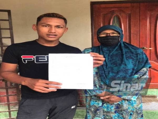 Fakhrul Idham Fakarudin (kiri) bersama ibunya menunjukkan laporan polis yang dibuat berhubung kehilangan bapanya sejak Khamis minggu lalu.