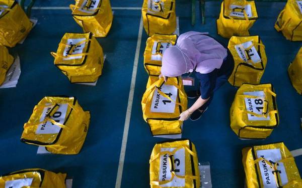 Kakitangan Suruhanjaya Pilihan Raya (SPR) Sarawak Nor Fazilah Ahmad menyusun kit peralatan mengundi untuk diagihkan ke pusat mengundi di seluruh negeri Sarawak. -Foto Bernama