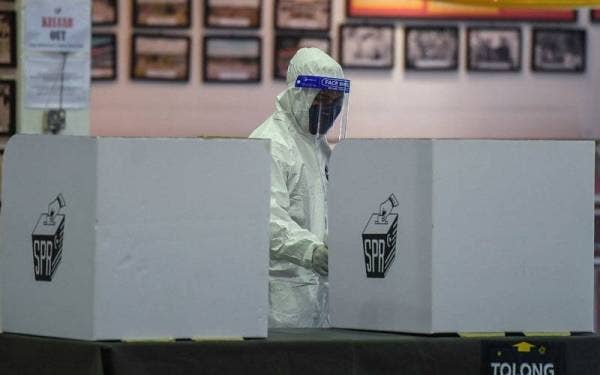 Kerja-kerja sanitasi dilakukan setiap satu jam di Pusat Pengundian pada hari mengundi awal PRN Sarawak Ke- 12 di Kem RASCOM Markas 9 Briged, Sibu hari ini. -Foto Bernama