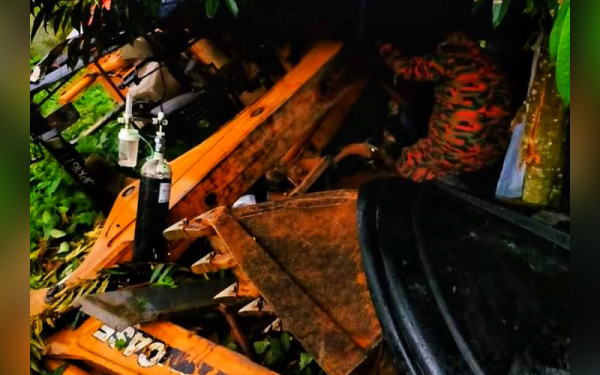 Anggota bomba berusaha mengeluarkan mangsa yang tersepit selepas jentera dipandu terbalik di Kampung Nabong dekat Benta di sini pada Rabu.- Foto ihsan Bomba