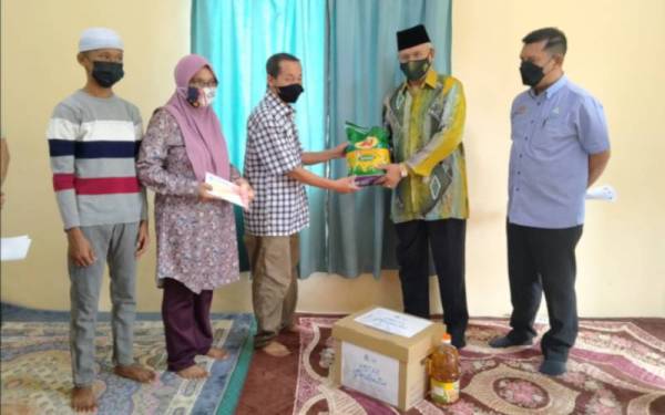 Najmi (dua dari kanan) menyampaikan sumbangan kepada bapa arwah Muhamad Ridhwan, Mokhtar Madun, 64, sambil disaksikan Mohamad Haron.