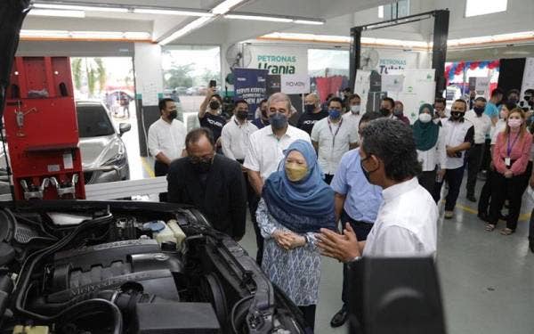 Pemilik OZI Holding, Noor Hijat Mohd Noor (kanan) memberi penerangan kepada Azizah (tengah) mengenai operasi Pusat Servis Kenderaan miliknya.