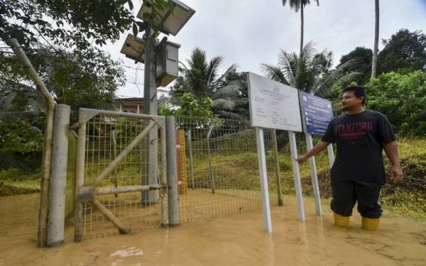 Penduduk setempat Ubaidillah Rosli, 29, meninjau stesen siren amaran awal banjir selepas peningkatan air Sungai Nal ketika tinjauan fotoBernama di Kampung Kuala Nal hari ini. -Foto Bernama
