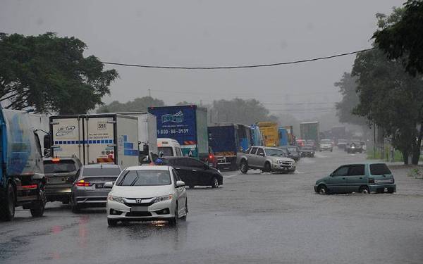Pengguna jalan raya terpaksa meredah banjir untuk ke Klang berikutan hujan lebat sejak semalam ketika tinjauan di Jalan Sungai Kandis hari ini. - Foto Bernama