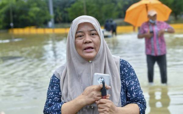 Ruzita menceritakan pengalaman pertamanya meredah banjir bagi menyelamatkan kertas peperiksaan akhir tahun subjek Geografi anak muridnya ketika ditemui di Kampung Chemperai, Dengkil hari ini. - Foto Bernama
