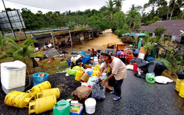 Khairuddin menyelamatkan barangan rumahnya yang dinaiki banjir