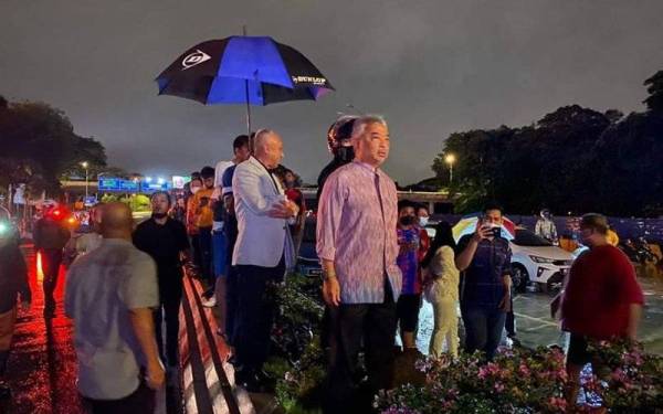 Tuanku berkenan menuruni kenderaan dalam keadaan hujan di jalan susur menghala ke Pusat Dagangan Dunia Putra (PWTC) dan meredah banjir bagi melihat sendiri situasi di sekitar kawasan tersebut.
