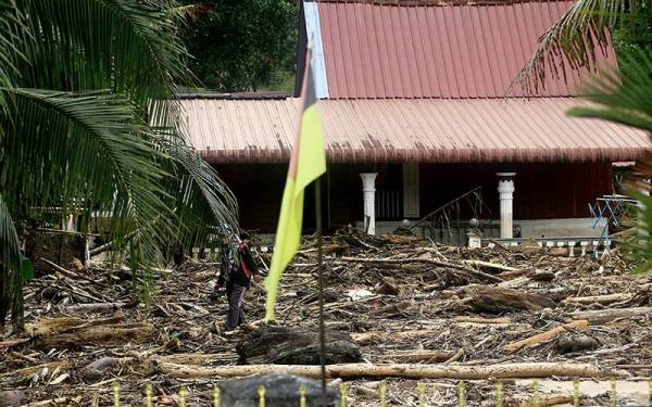 Kerja-kerja pembersihan dijangka mengambil masa lebih seminggu untuk mengangkat timbunan kayu serta pokok besar dan membersihkan lumpur di dalam rumah. - Foto Bernama