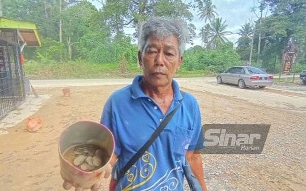 Ibrahim menunjukkan salah satu tabung yang ditemuinya masih berisi duit syiling.