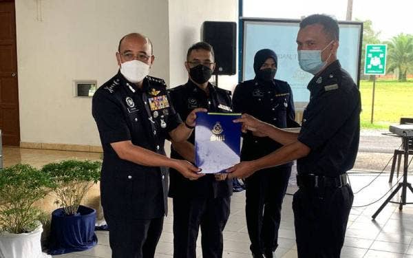 Shafien (kiri) menyampaikan sijil kepada anggota yang menerima penganugerahan pada Ahad.