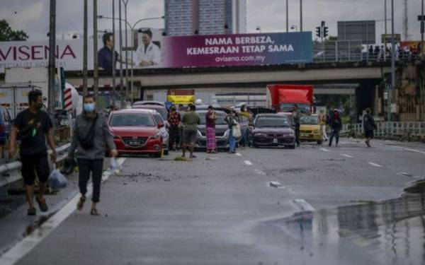 Deretan kenderaan yang terjejas ekoran banjir kilat di Batu 3, Lebuhraya Persekutuan akibat limpahan air dari Sungai Damansara sehingga mengakibatkan jalan ditenggelami air dan tidak boleh dilalui oleh kenderaan ketika tinjauan pada Ahad. - Foto Bernama