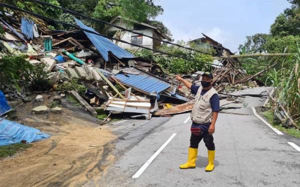 Mohd Razif menunjukkan sembilan rumah ranap akibat tanah runtuh di Kampung Palimbayan Sungai Penchala, Damansara pada jam 12.30 tengah malam Ahad.