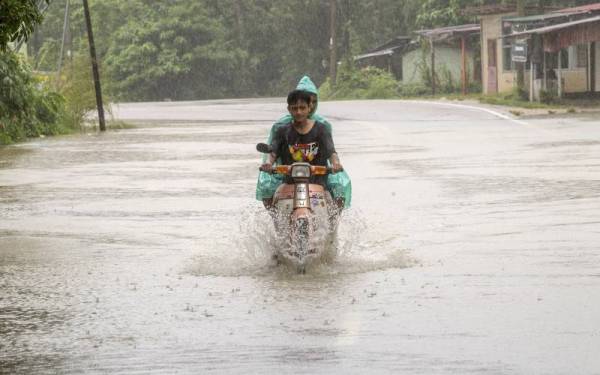 Penduduk kampung terpaksa meredah banjir sedalam 0.5 meter berikutan hujan lebat sejak beberapa hari lalu ketika tinjauan di Jalan Lebai Leh, di Kampung Ulu Kusial Tanah Merah pada Sabtu. - Foto Bernama