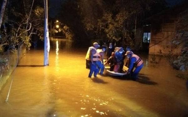 Angkatan Pertahanan Awam Malaysia (APM) membantu memindahkan mangsa banjir ke PPS berhampiran. Foto Ihsan APM