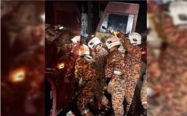 Operasi mengeluarkan pemandu sebuah bas yang tersepit dalam nahas pagi Isnin. - Foto ihsan Bomba Perak