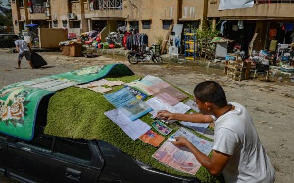 Penduduk Pangsapuri Perdana Muhammad Ridwan Abdul Kadir menjemur dokumen peribadi yang berjaya diselamatkan selepas kawasan kediamannya dilanda banjir ketika tinjauan di Seksyen 13 hari ini.