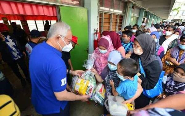 Najib menyampaikan bantuan keperluan asas kepada mangsa banjir di Padang Jawa pada Isnin.