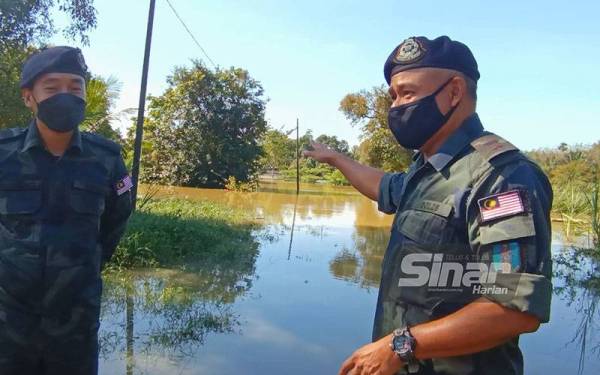 Azhari (kanan) dan pegawainya turun padang membuat tinjauan penugasan banjir di Pos Ibrahim Pencen yang ditenggelami banjir di Rantau Panjang pada Isnin.