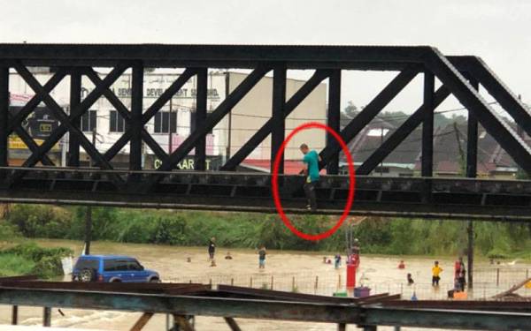 Aksi seorang lelaki yang meniti di atas bahagian tepi besi landasan kereta api di Gertak Caber, Tanah Merah pada petang Ahad.