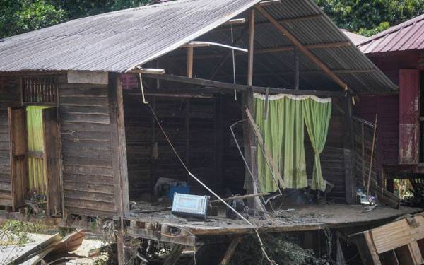 Sebuah rumah di Kampung Batu 18 yang beralih dari tapak asal akibat dibawa arus banjir ketika tinjauan pada Isnin.
