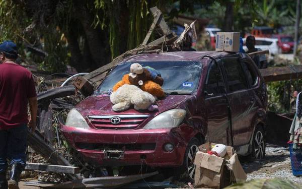 Penduduk Pekan Batu 18 mula membersihkan kediaman masing-masing selepas banjir mulai surut ketika tinjauan pada Isnin. - Foto Bernama