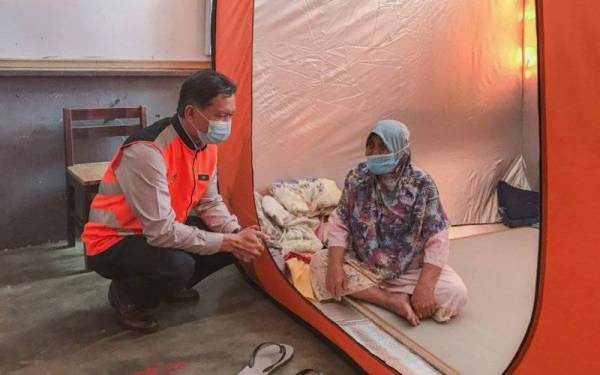 Pengarah Jabatan Kebajikan Masyarakat (JKM), Said Sidup (kiri) bertanyakan sesuatu kepada Che Som sewaktu meninjau PPS di Sekolah Kebangsaan Gual Tinggi, Rantau Panjang. - Foto Bernama
