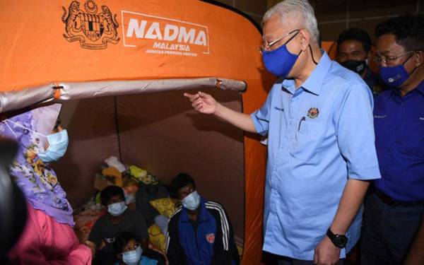 Ismail Sabri (dua, kanan) melawat mangsa banjir yang ditempatkan di Pusat Pemindahan Sementara (PPS) Dewan Besar D'Sury, Kuala Klawang pada Selasa. - Foto Bernama