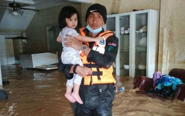 Salah seorang anggota PGA Semenyih membantu kanak-kanak yang menjadi mangsa banjir di kawasan Hulu Langat.