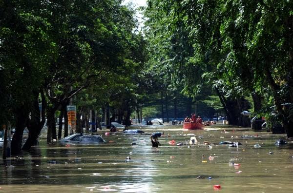 Kelihatan mangsa banjir meredah air untuk menyelamatkan diri ketika tinjauan di Taman Seri Muda Seksyen 25. -Foto Bernama