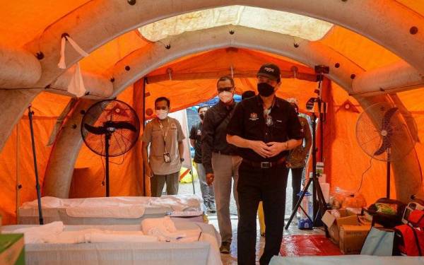 Ketua Pengarah Kesihatan Tan Sri Dr Noor Hisham Abdullah (kanan) meninjau kelengkapan fasiliti kesihatan rawatan awal di Pusat Operasi Medan Kementerian Kesihatan (KKM) di Jambatan Taman Sri Muda, Seksyen 25 hari ini. - Foto Bernama