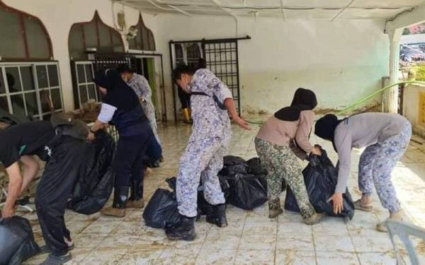 Pasukan ATM sedang mengumpul sampah yang perlu dibuang akibat banjir.