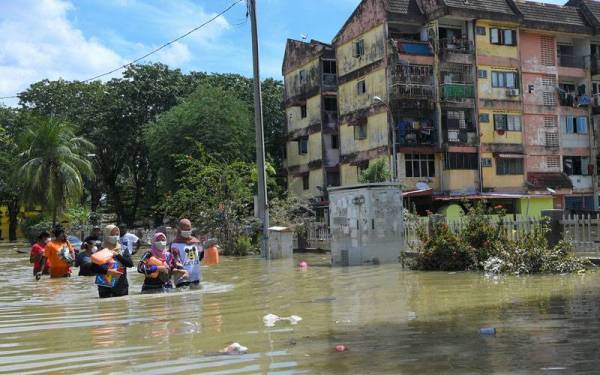 Mangsa-mangsa banjir di Taman Seri Muda Seksyen 25 mengambil bekalan makanan berikutan banjir yang masih belum surut sepenuhnya. - Foto Bernama