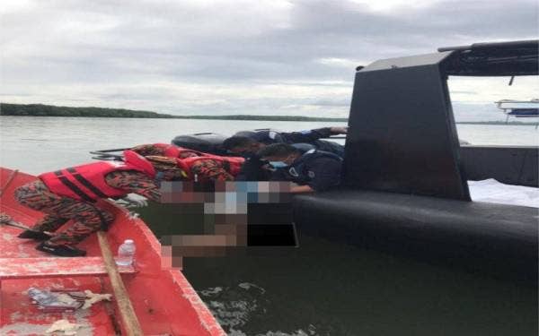 Anggota bomba mengangkat mayat mangsa yang ditemui di perairan Pulau Semayang.