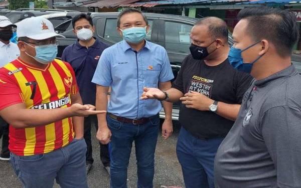 Dari kiri, Amirudin (kiri), Sze Han dan Ramli ketika membuat tinjauan operasi pembersihan KDEBWM Pasca Banjir di Padang Jawa pada Khamis. 