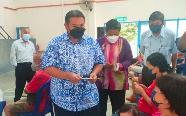 Rais ketika menyampaikan sumbangan Hari Natal kepada penerima di Dewan Paya Emas pada Khamis.