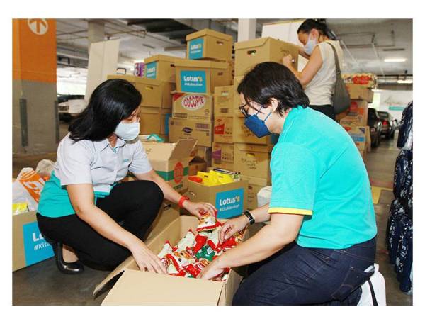 Azliza Azmel (kiri) turut sama menyiapkan barangan keperluan yang disumbangkan oleh orang ramai.