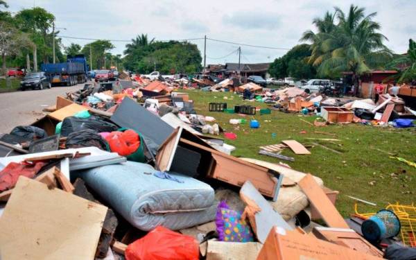Longgokan sampah sarap dan perkakasan rumah yang rosak akibat banjir di satu kawasan lapang sebelum diuruskan pelupusannya oleh pihak berwajib. -Foto Bernama