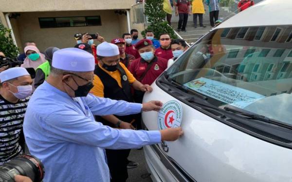 Ahmad melekatkan pelekat kenderaan sebagai gimik pelepasan Misi Pemulihan Bantuan Banjir Kelantan ke Pahang di Kompleks Kota Darulnaim di Kota Bharu pada Jumaat.